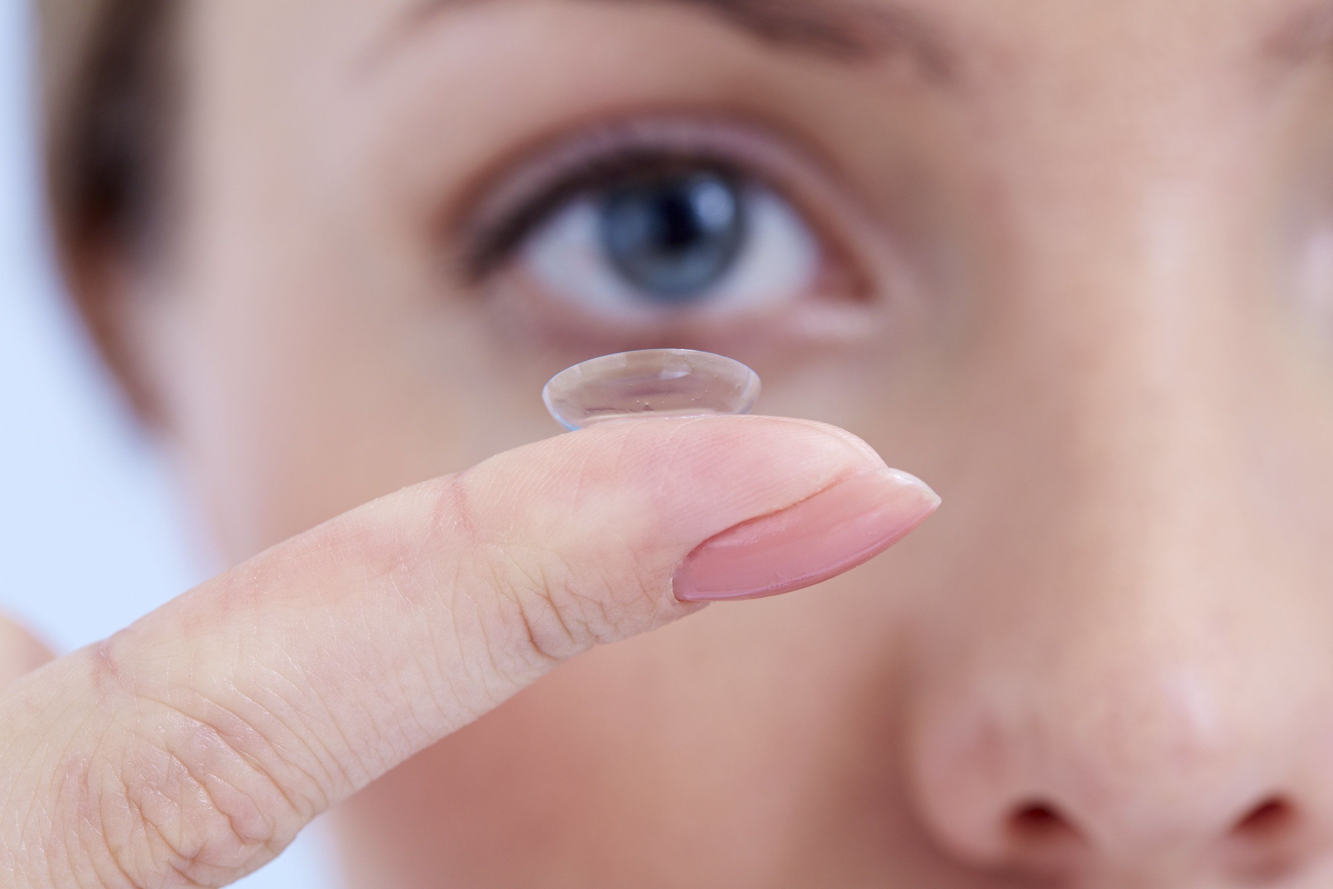 A woman holding a contact lens